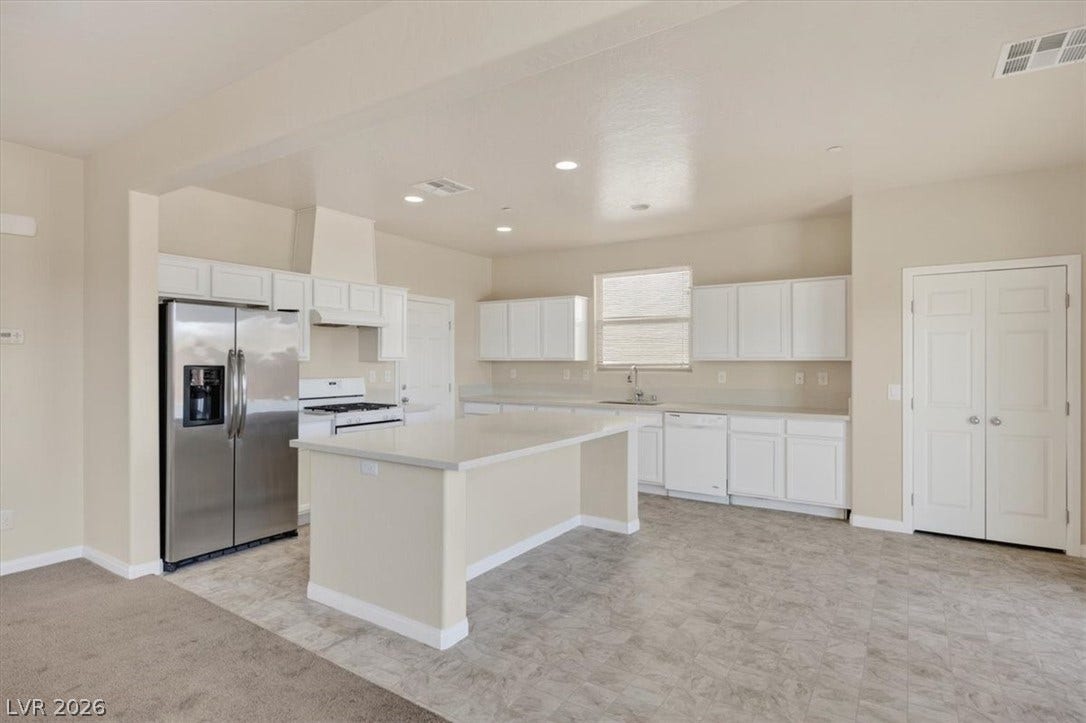 1116 Strada Cristallo, Henderson, NV 89011 A well-appointed kitchen features a large island and ample white cabinetry, perfect for culinary endeavors.
