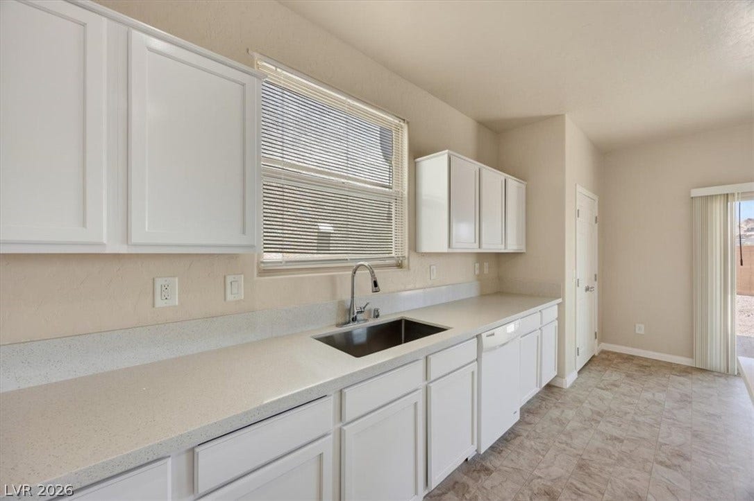 1116 Strada Cristallo, Henderson, NV 89011 White cabinetry and stone-look counters complement the bright kitchen area.