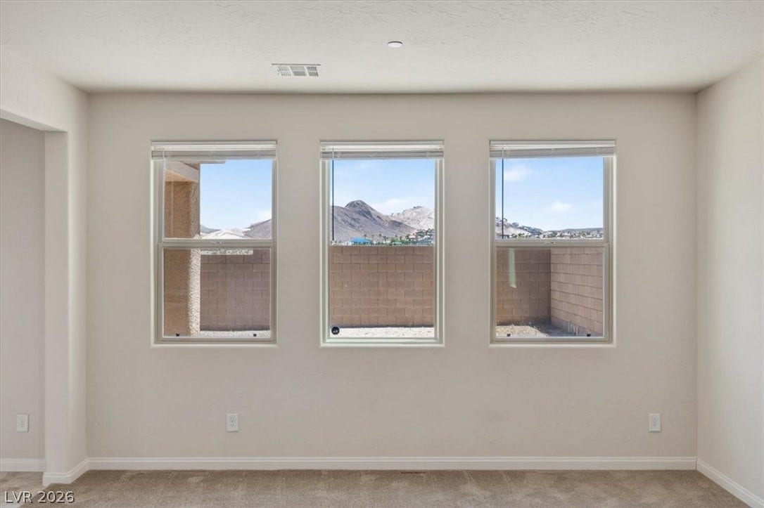 1116 Strada Cristallo, Henderson, NV 89011 Admire mountain vistas through three generous windows, framing a serene desert landscape.