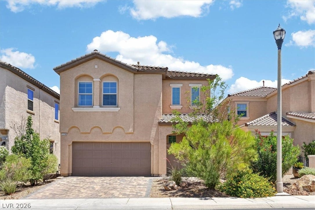 1116 Strada Cristallo, Henderson, NV 89011 A charming two-story residence with a paved driveway and desert landscaping awaits.