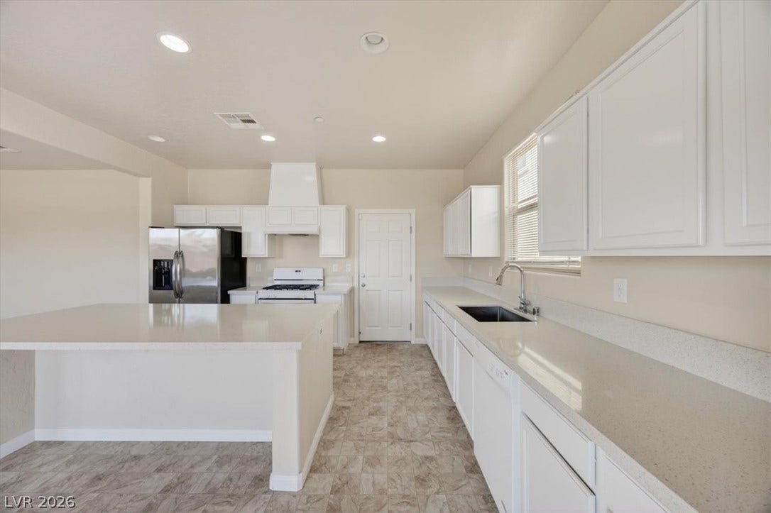 1116 Strada Cristallo, Henderson, NV 89011 A well-equipped kitchen features bright white cabinetry and modern appliances, perfect for culinary endeavors.