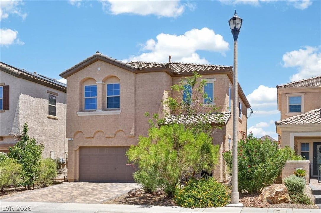 1116 Strada Cristallo, Henderson, NV 89011 A terracotta-hued facade with arched window accents and a patterned driveway awaits.