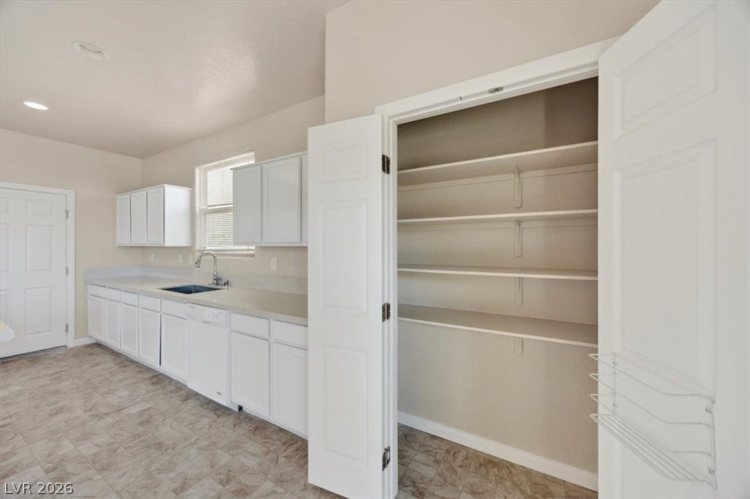 1116 Strada Cristallo, Henderson, NV 89011 White cabinetry lines this clean kitchen, complete with a convenient pantry and ample counter space.