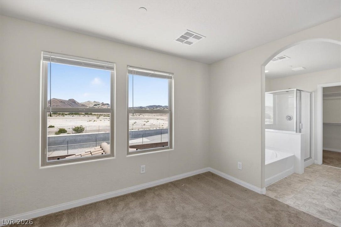 1116 Strada Cristallo, Henderson, NV 89011 Two large windows provide desert mountain views from this cozy primary bedroom with an attached bath.