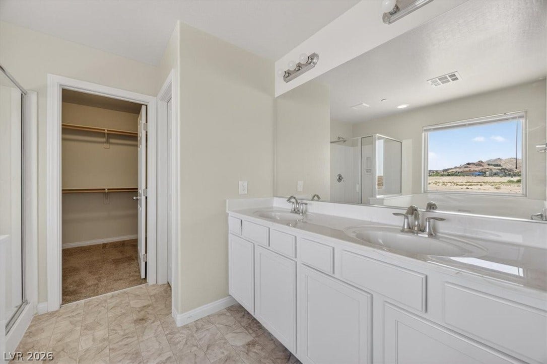 1116 Strada Cristallo, Henderson, NV 89011 Double vanity with ample counter space and a large mirror overlooking picturesque desert hills.