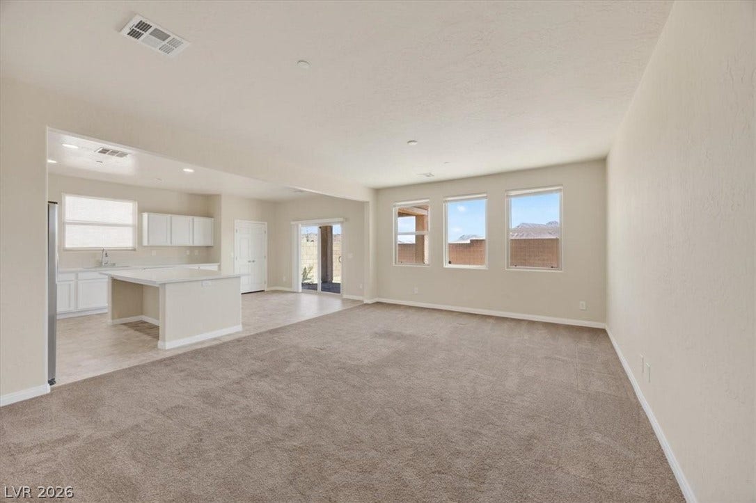 1116 Strada Cristallo, Henderson, NV 89011 An inviting open-concept space features warm carpeting and abundant natural light.
