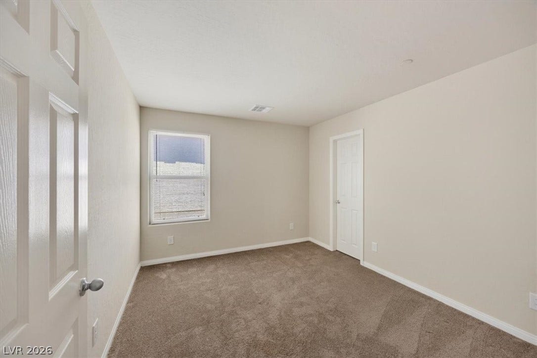 1116 Strada Cristallo, Henderson, NV 89011 A spacious, naturally illuminated room featuring warm neutral walls and soft carpeting for ultimate comfort.