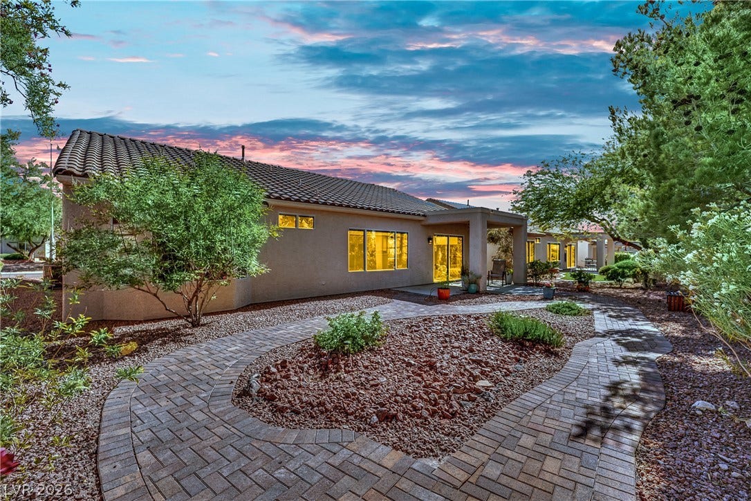 This tranquil outdoor space features a paver pathway leading to a charming patio area, perfect for relaxation.