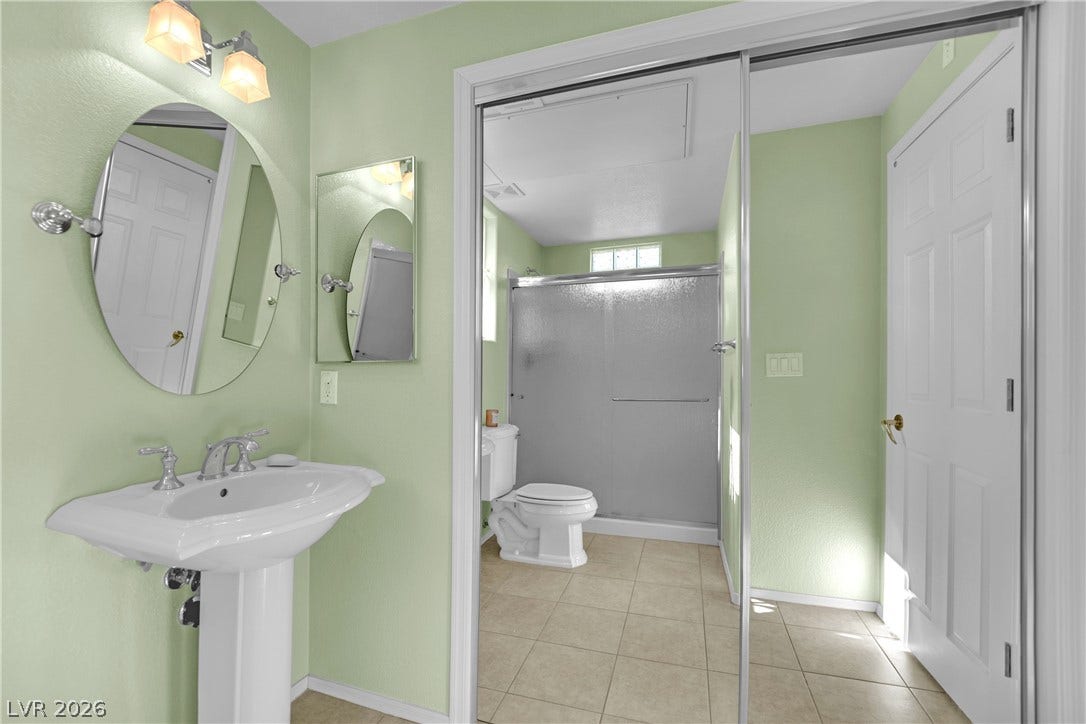 This clean and bright bathroom features a pedestal sink, walk-in shower, and ample natural light.