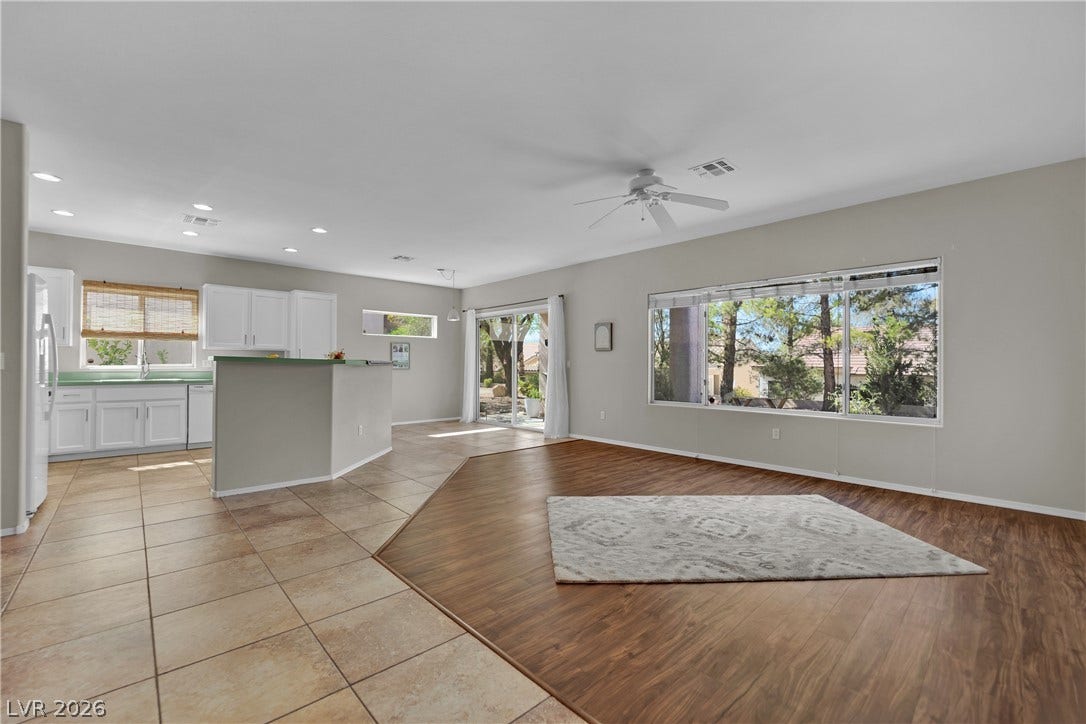 This bright, open-concept living space features diverse flooring and a kitchen island, perfect for entertaining.
