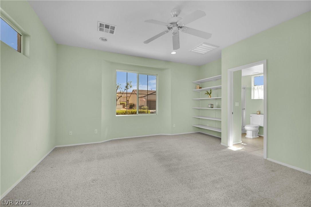 This airy room offers a bright window view and convenient access to a private bathroom.