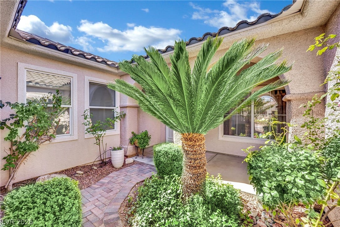 Lush landscaping and a paver pathway welcome you to this charming residence.