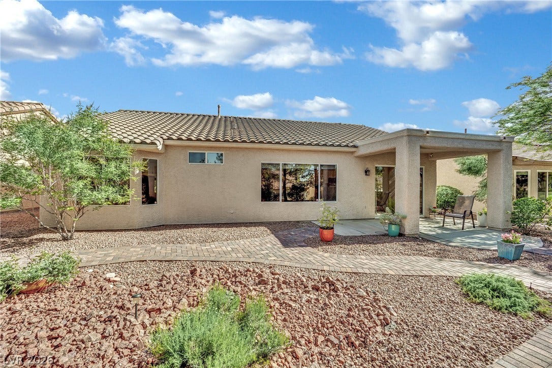 This tranquil outdoor space features a covered patio perfect for relaxation and enjoying the private yard.