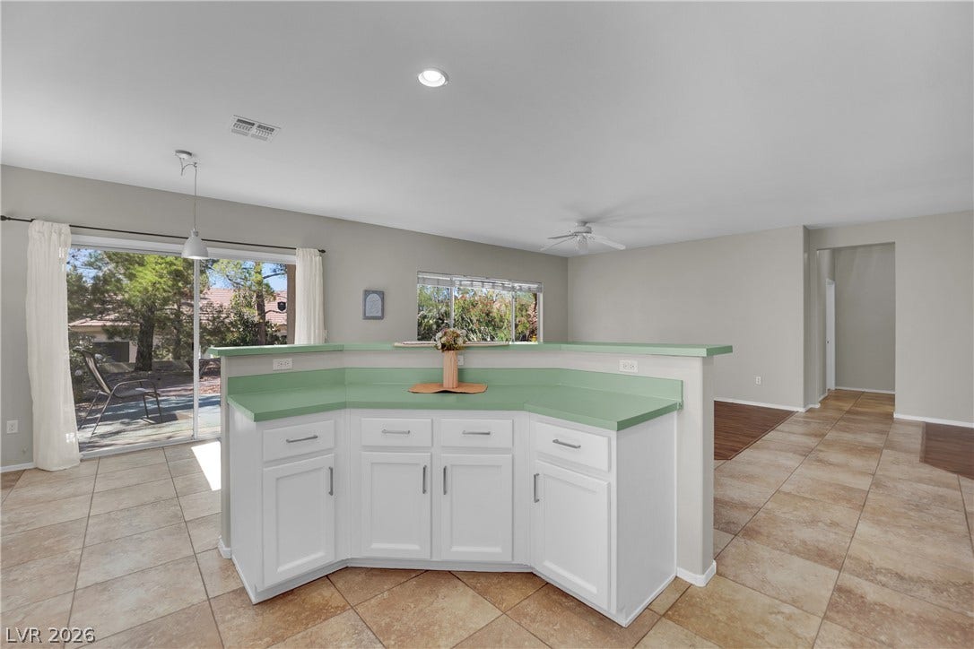 This bright kitchen and dining area features outdoor access and ample countertop space.