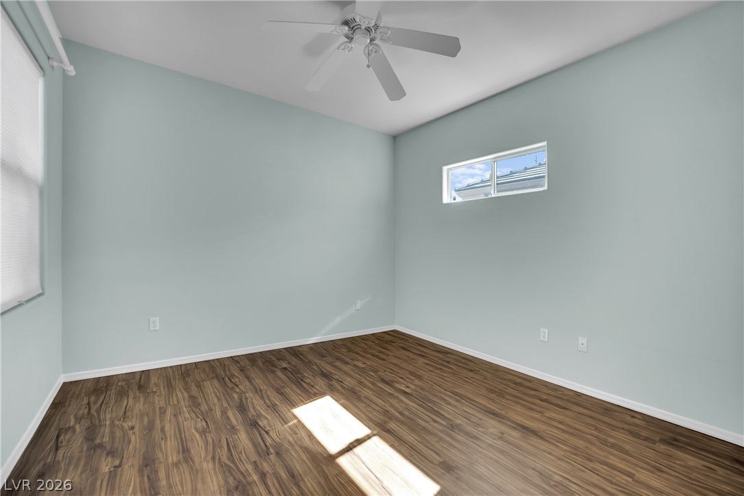 This airy bedroom features elegant flooring and abundant natural light.