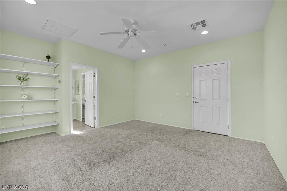 This spacious room features ample shelving and a ceiling fan, offering comfortable living.