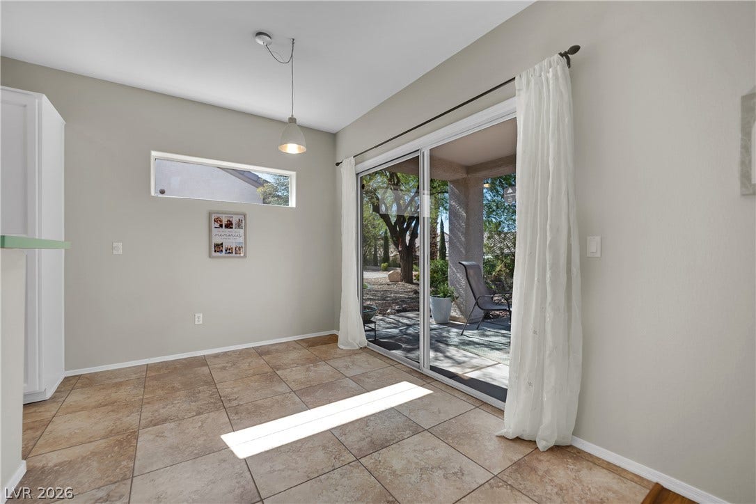 This bright space features sleek tile flooring and a spacious sliding glass door leading to the outdoors.