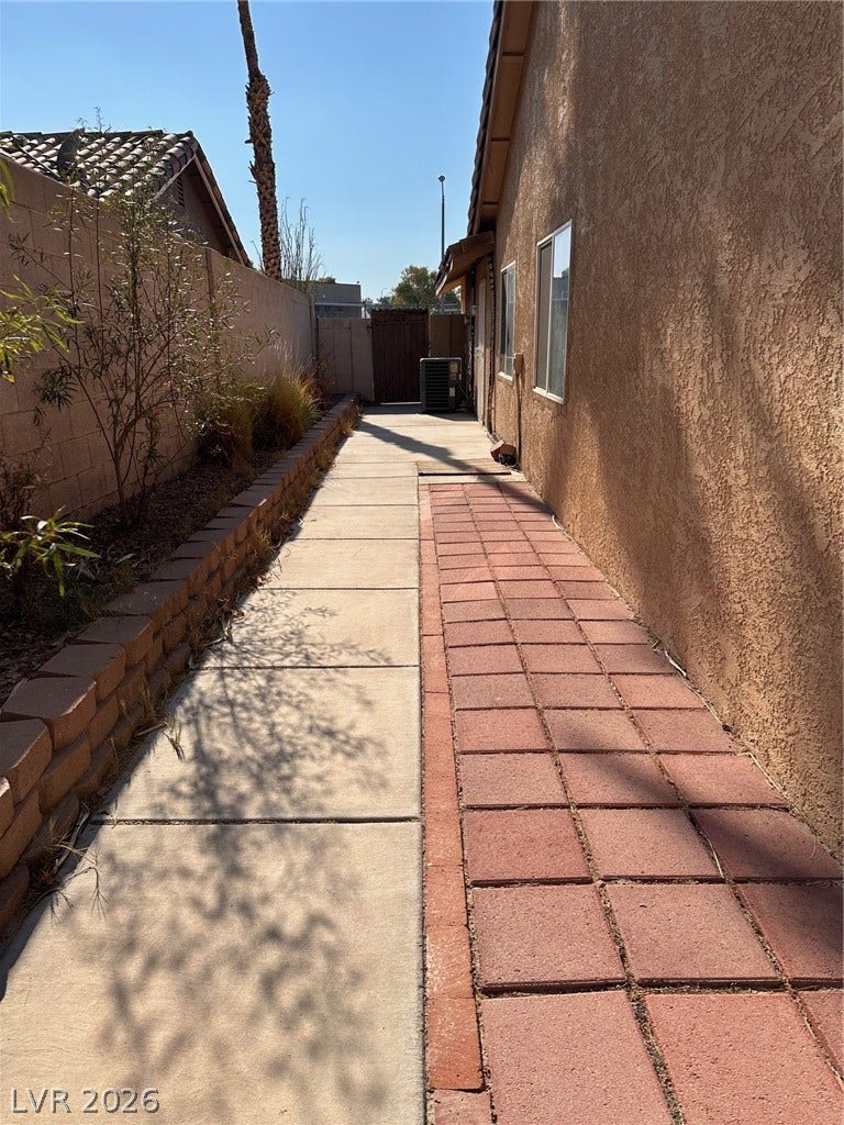 2340 Viewcrest Road, Henderson, NV 89014 This outdoor pathway features a mix of concrete and brick pavers, leading to the back of the property.