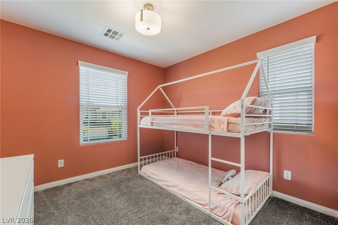 360 Misterioso Street, Henderson, NV 89011 This cozy bedroom features plush carpet and ample natural light from two windows.