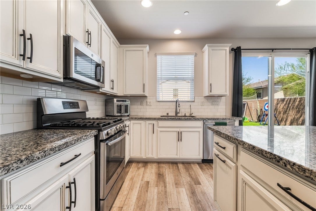 360 Misterioso Street, Henderson, NV 89011 This bright kitchen features ample counter space, modern appliances, and a seamless connection to the outdoors.