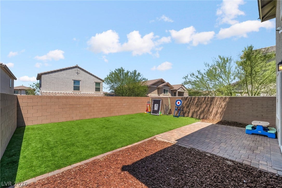 360 Misterioso Street, Henderson, NV 89011 This outdoor space offers a paved patio, a vibrant green lawn, and thoughtful landscaping.