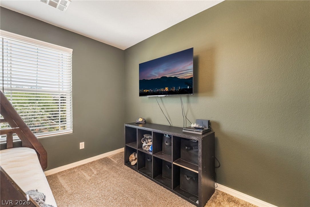 360 Misterioso Street, Henderson, NV 89011 This cozy bedroom features plush carpet and a bright window, perfect for comfortable living.