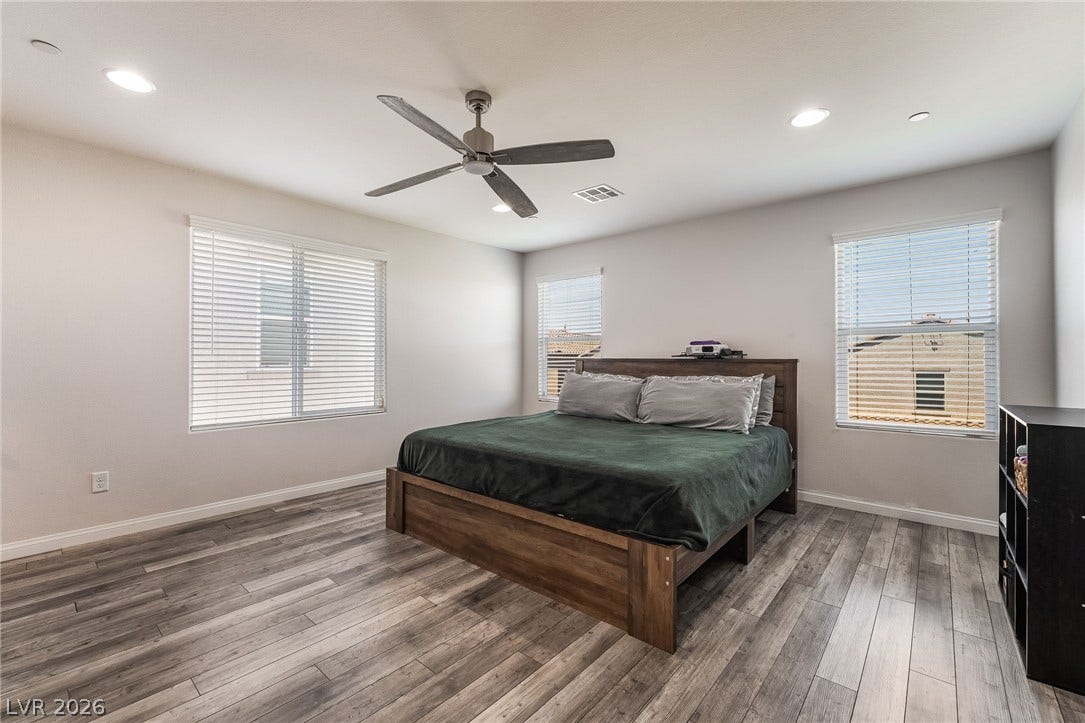 360 Misterioso Street, Henderson, NV 89011 This airy bedroom features modern flooring and ample natural light, creating a refreshing personal sanctuary.