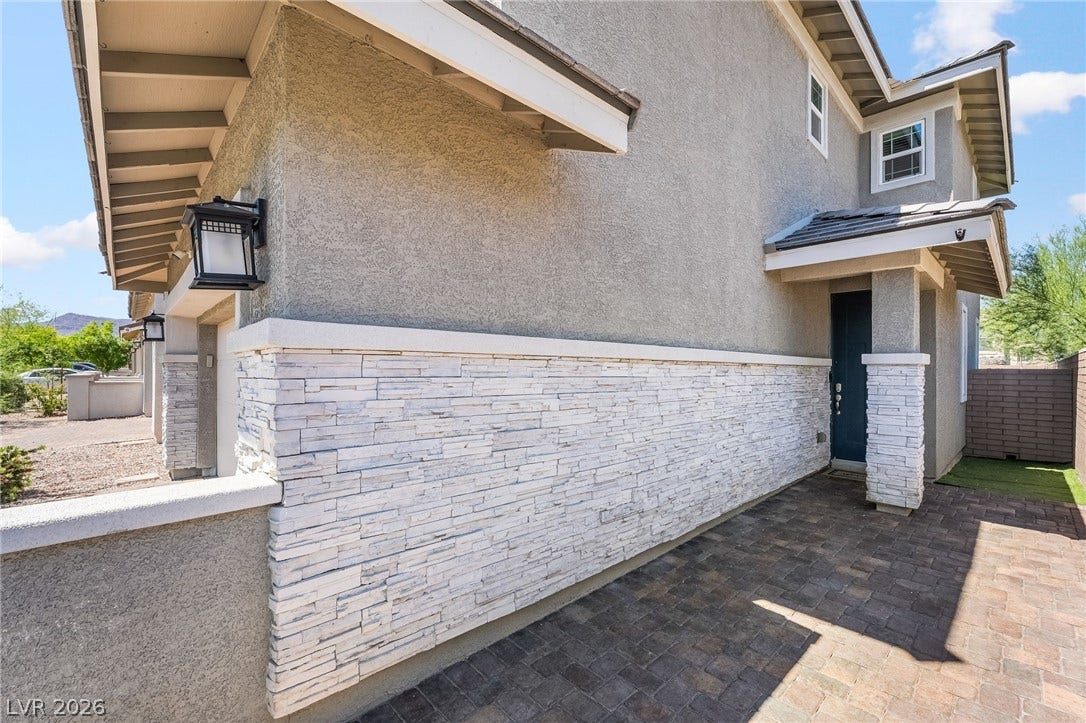 360 Misterioso Street, Henderson, NV 89011 This residence showcases a modern facade with textured stucco and elegant stone accents.
