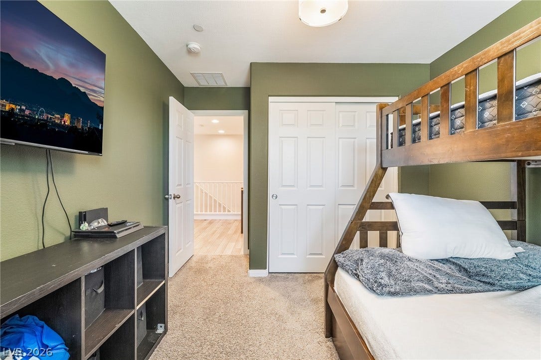 360 Misterioso Street, Henderson, NV 89011 This cozy bedroom features comfortable carpeting and convenient closet space, perfect for relaxation and storage.