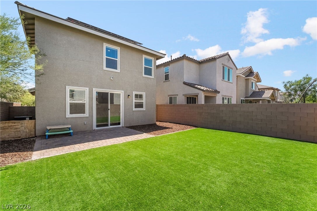360 Misterioso Street, Henderson, NV 89011 This private yard offers a spacious patio area and vibrant green lawn, perfect for outdoor enjoyment.