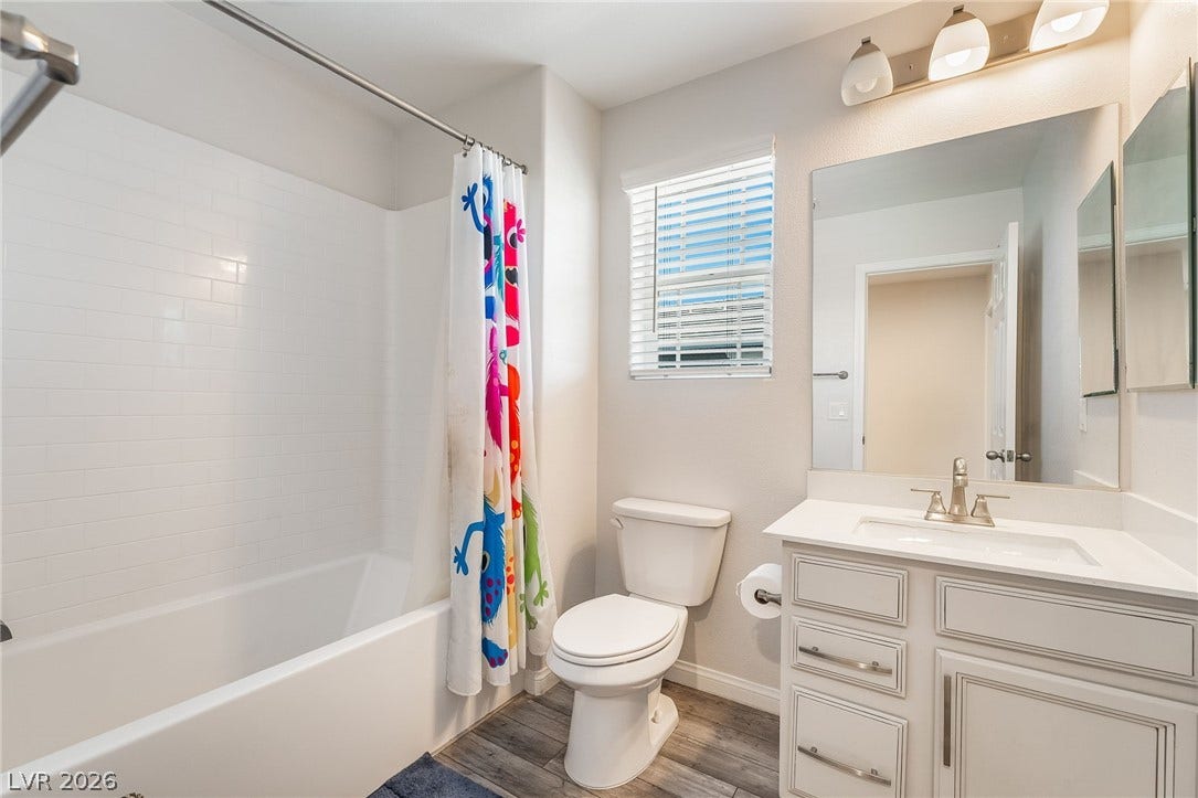 360 Misterioso Street, Henderson, NV 89011 This bright bathroom features a spacious tub, elegant vanity, and wood-look flooring.