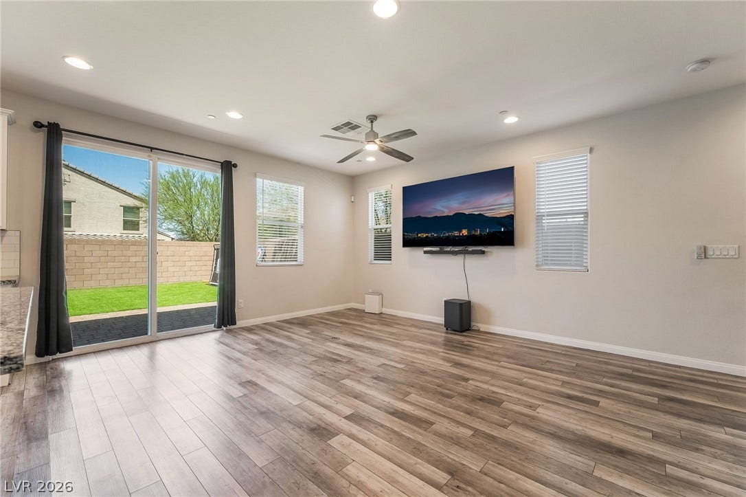 360 Misterioso Street, Henderson, NV 89011 This bright living area features sleek wood flooring and a sliding glass door to the private yard.