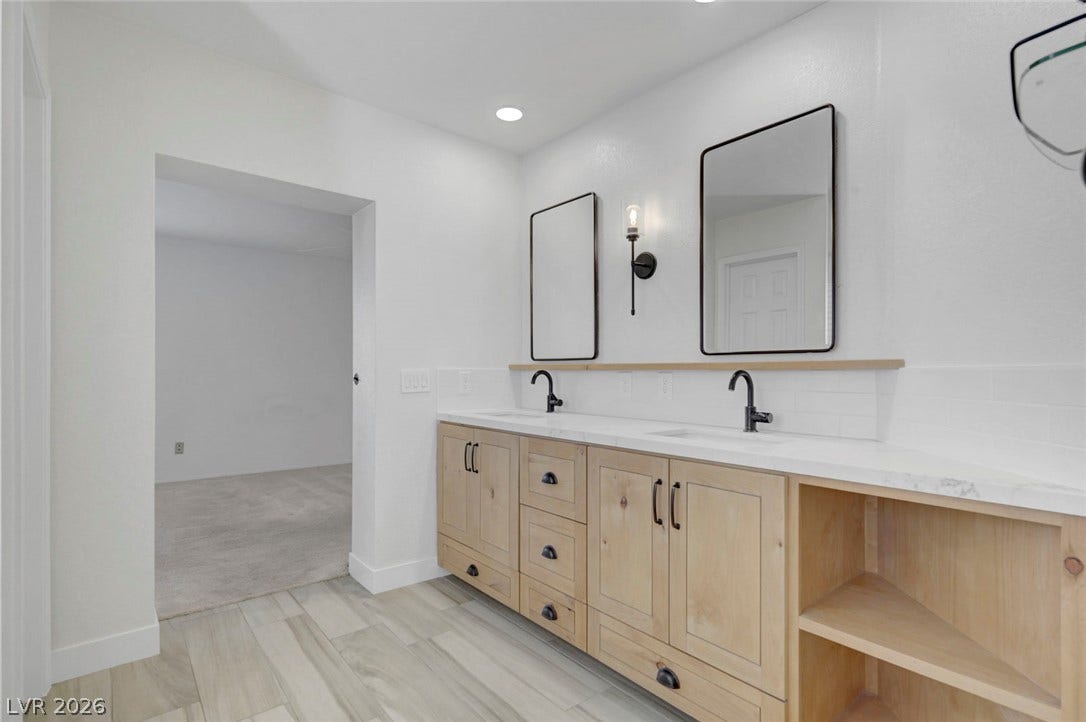 31 Antero Drive, Henderson, NV 89074 A sleek, contemporary double vanity with modern fixtures and ample storage anchors this well-appointed bathroom.