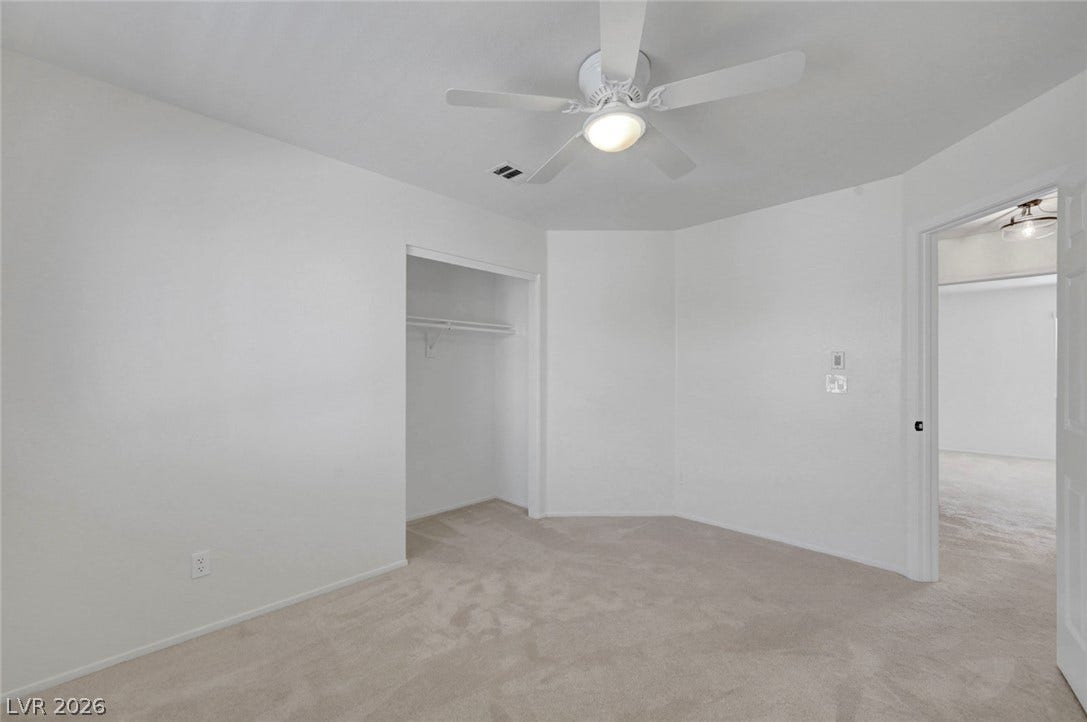 31 Antero Drive, Henderson, NV 89074 A well-lit bedroom features plush carpeting and an integrated ceiling fan for comfort.