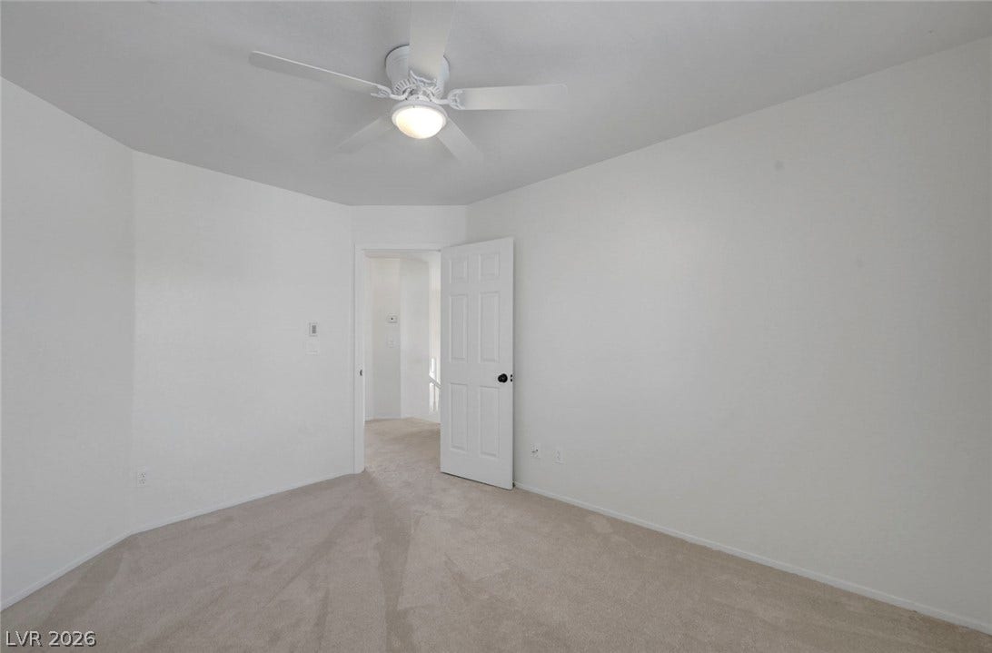 31 Antero Drive, Henderson, NV 89074 A tranquil bedroom space features a ceiling fan and plush carpeting, offering a peaceful retreat.