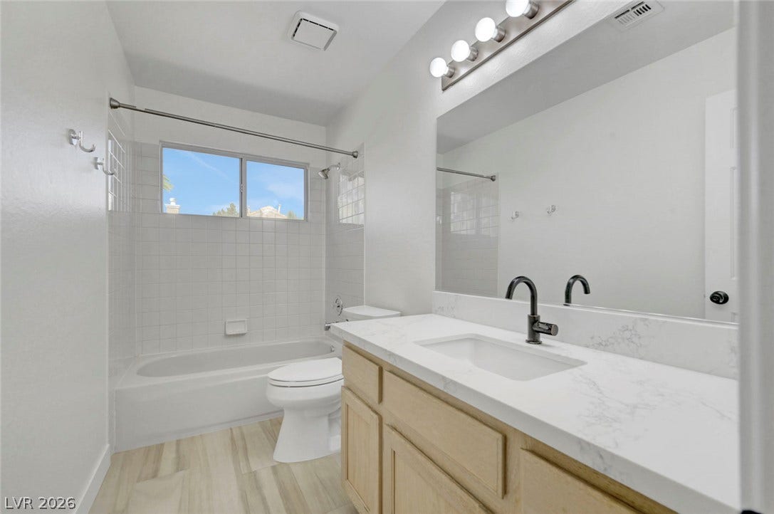 31 Antero Drive, Henderson, NV 89074 A well-appointed bath features a sleek vanity, mirror, and modern fixtures alongside a tub/shower combination.