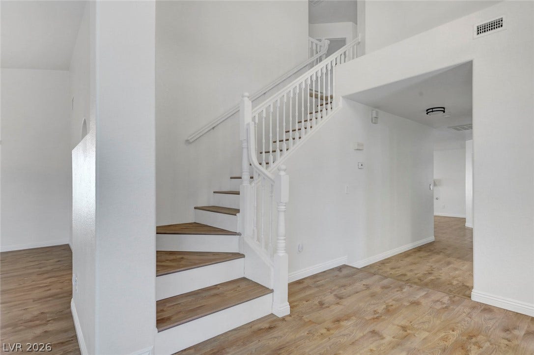 31 Antero Drive, Henderson, NV 89074 A graceful staircase with wood treads ascends from the main living area, complementing the plank flooring.