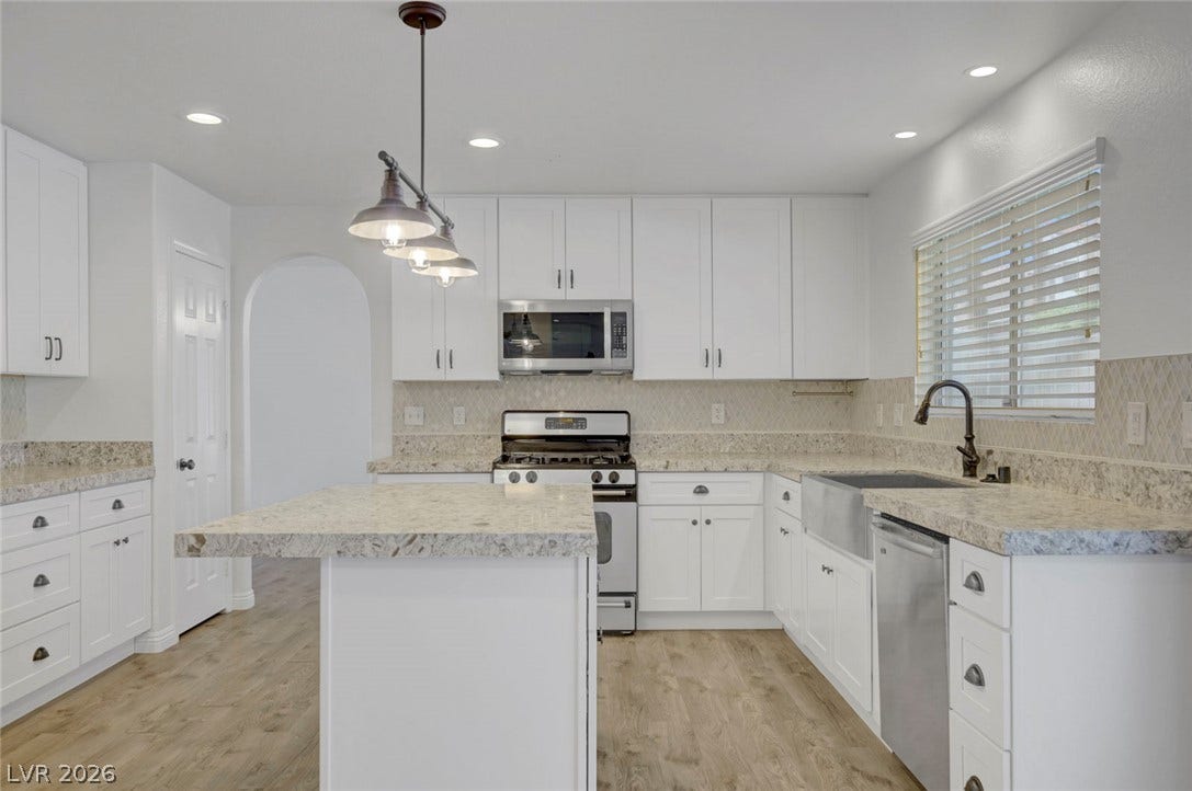 31 Antero Drive, Henderson, NV 89074 A well-appointed kitchen features white cabinetry, granite countertops, and modern appliances.