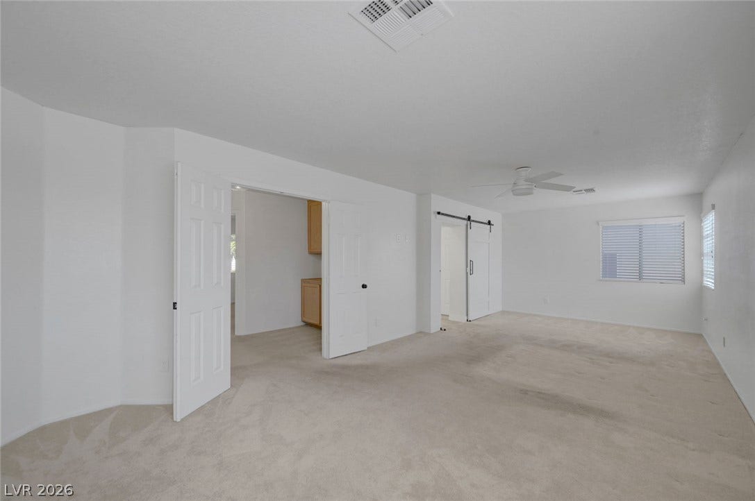 31 Antero Drive, Henderson, NV 89074 A spacious, naturally illuminated room featuring neutral carpeting and a ceiling fan for comfort.
