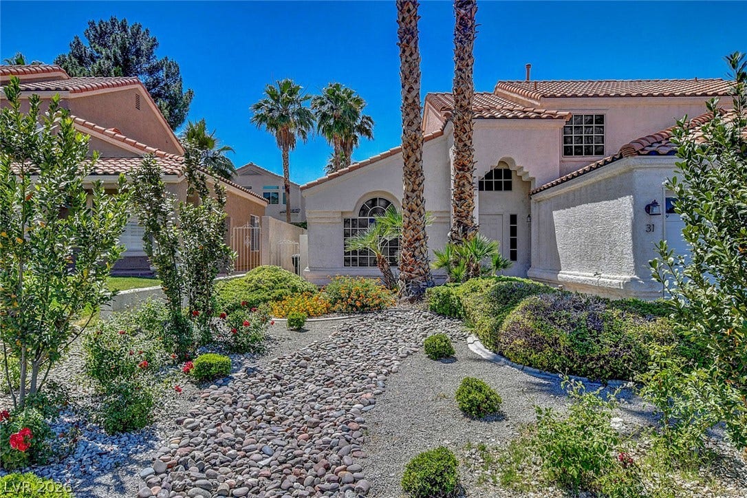 31 Antero Drive, Henderson, NV 89074 A desert-inspired landscape with natural rock pathways and lush, low-water plantings leads to a welcoming home.