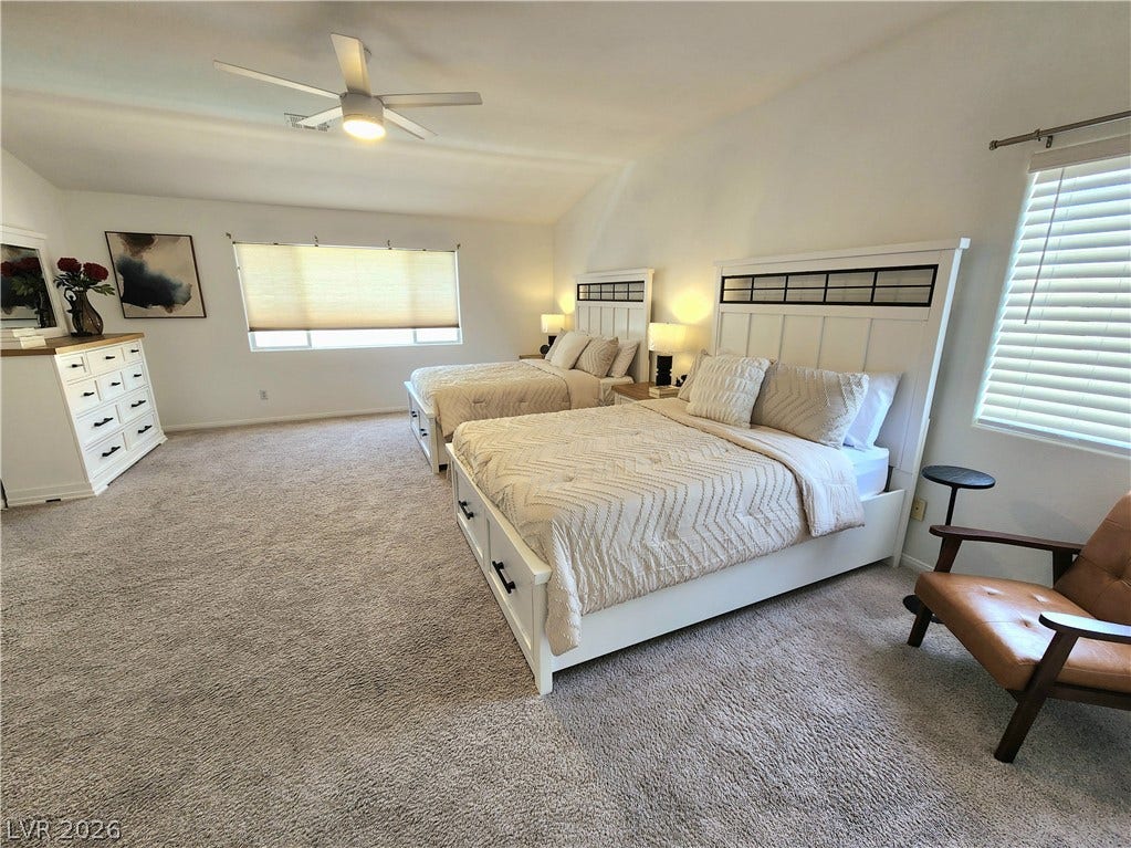 2743 Peekskill Avenue, Henderson, NV 89052 This spacious bedroom offers comfortable carpeting and natural light, creating a serene and inviting atmosphere.