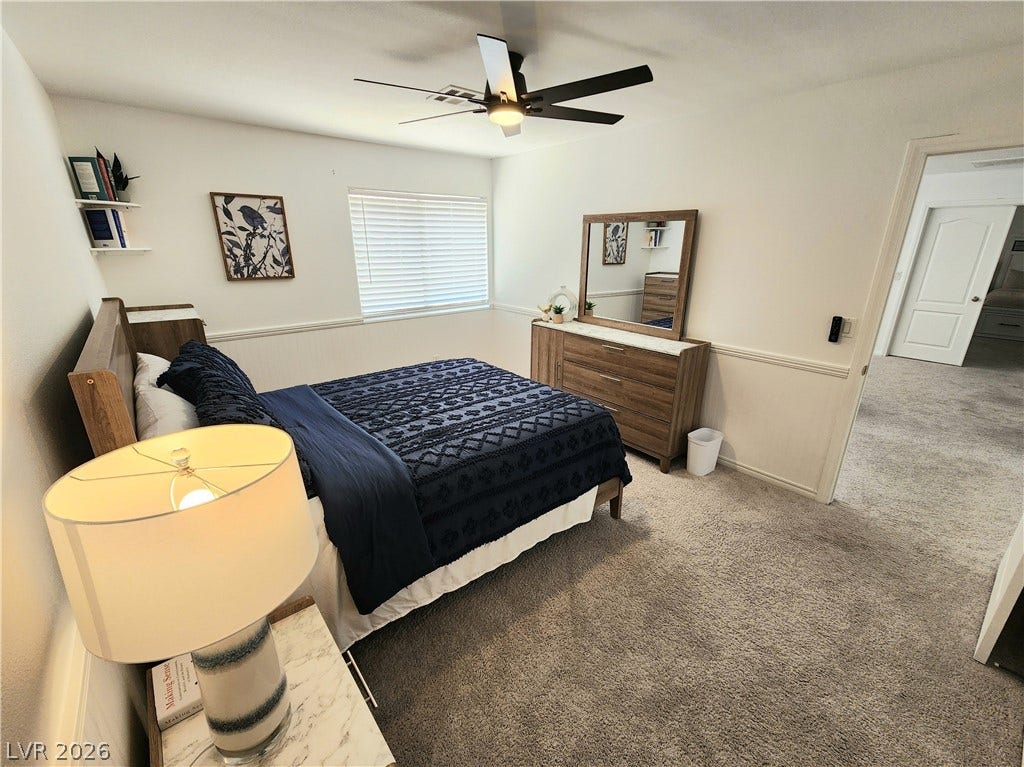 2743 Peekskill Avenue, Henderson, NV 89052 This cozy bedroom features plush carpeting and a modern ceiling fan, creating a comfortable and inviting atmosphere.