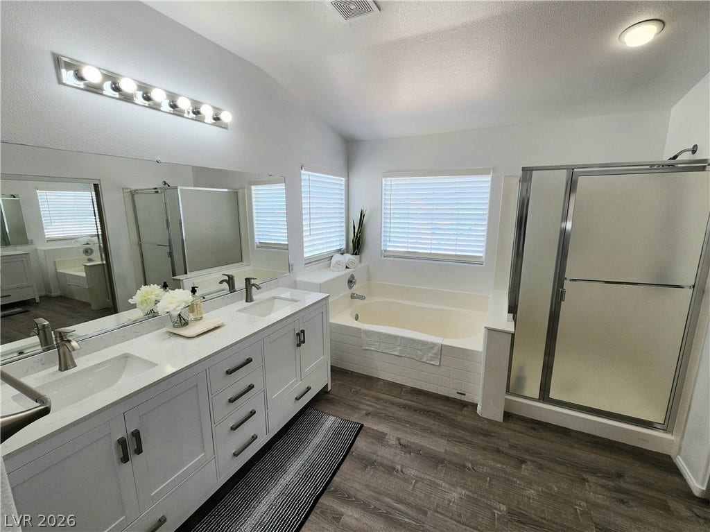 2743 Peekskill Avenue, Henderson, NV 89052 This spacious primary bathroom offers dual vanities, a separate soaking tub, and a glass-enclosed shower.