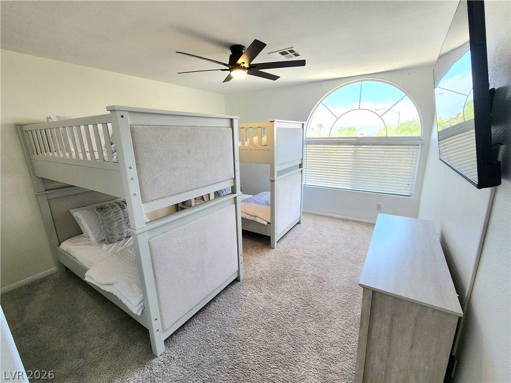 2743 Peekskill Avenue, Henderson, NV 89052 This spacious bedroom features ample natural light and comfortable carpeting, perfect for relaxation.