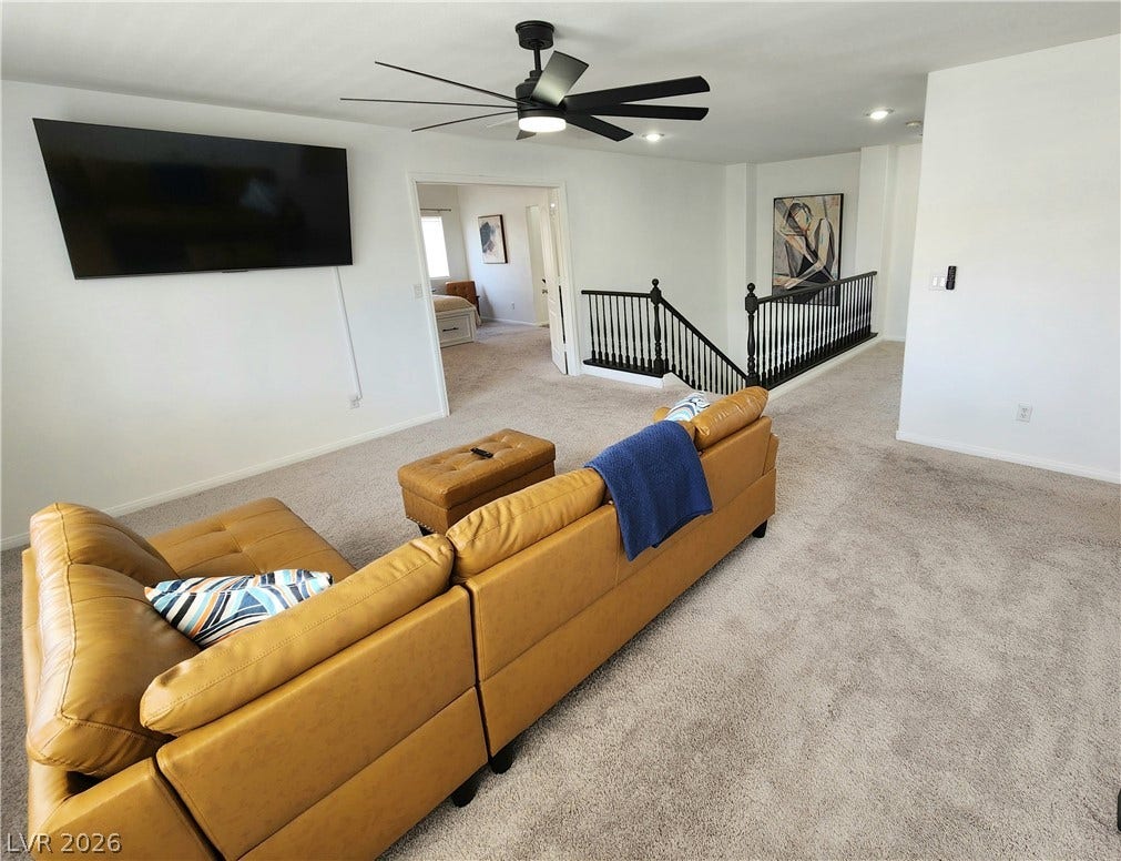 2743 Peekskill Avenue, Henderson, NV 89052 This inviting living area features a spacious layout with a view of the adjacent bedroom and staircase.