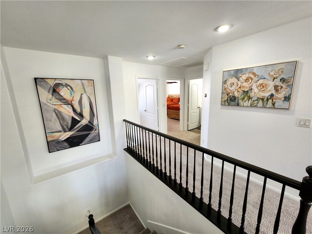 2743 Peekskill Avenue, Henderson, NV 89052 This interior hallway features carpeted flooring, leading to several rooms with bright white doors and recessed lighting.