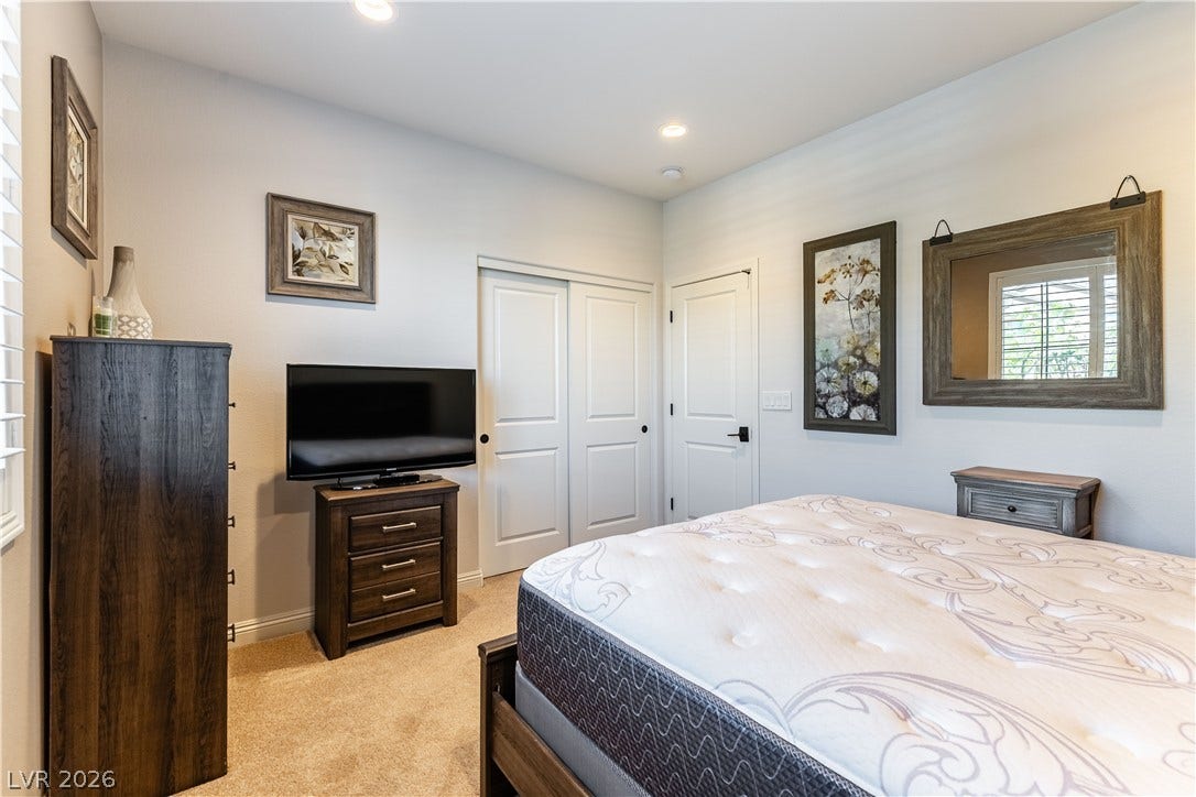 900 San Laurent Court, Henderson, NV 89012 Recessed lighting illuminates this cozy bedroom, creating a tranquil retreat for rest and relaxation.
