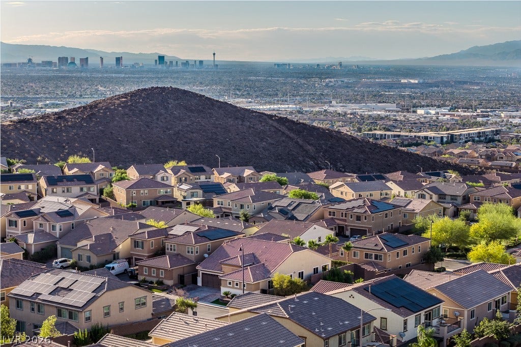900 San Laurent Court, Henderson, NV 89012 An aerial perspective showcases a residential neighborhood nestled below a mountain, with a strip view from the second primary/loft upstairs.