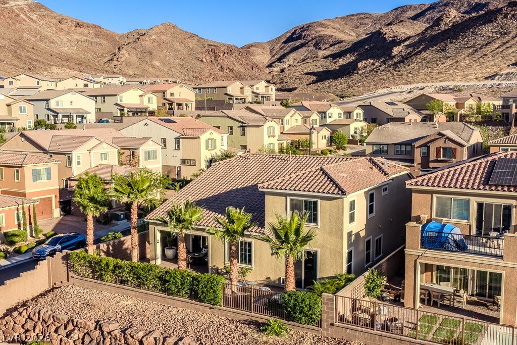 900 San Laurent Court, Henderson, NV 89012 An aerial perspective reveals a vibrant neighborhood nestled against the dramatic backdrop of rugged mountains.