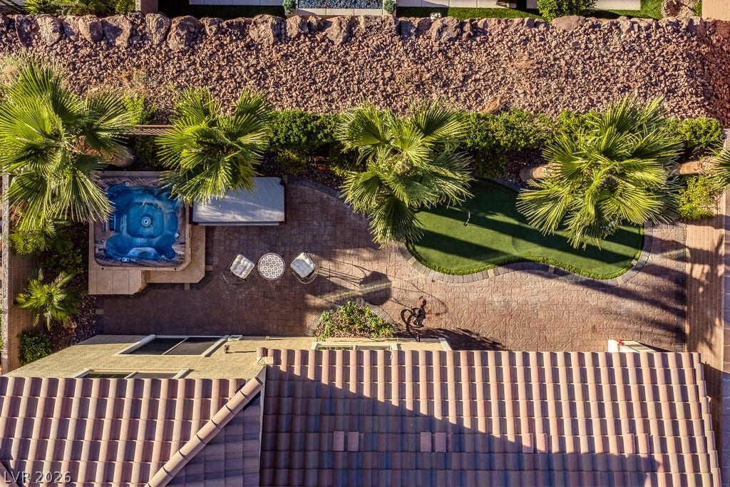 900 San Laurent Court, Henderson, NV 89012 An aerial perspective reveals a private spa, putting green, and lush landscaping on a tiled patio.